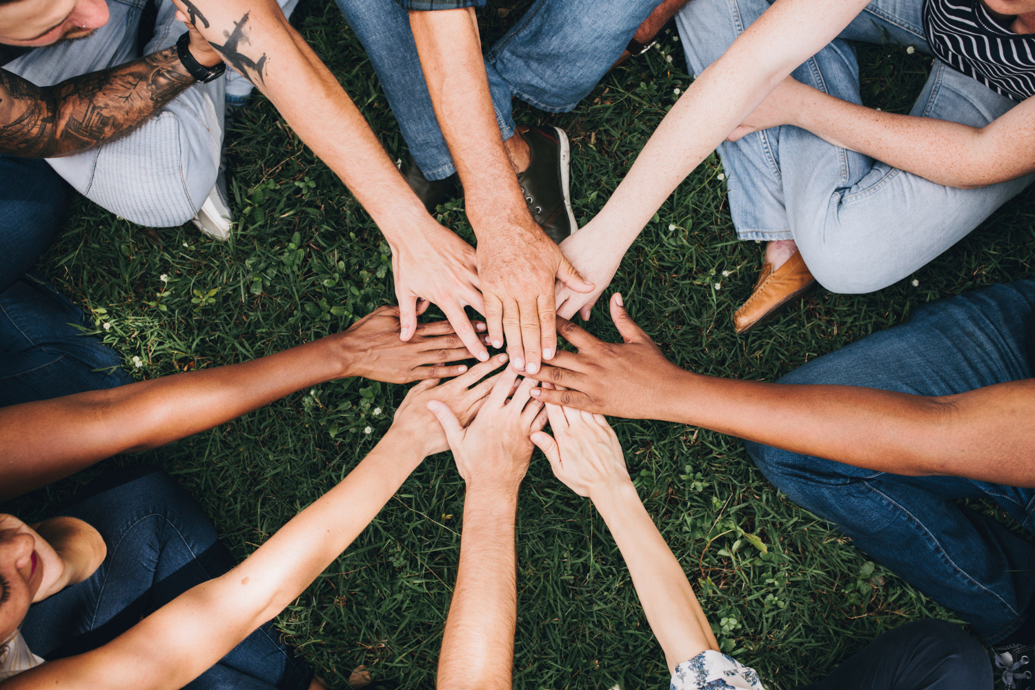 people-stacking-hands-together-in-the-park